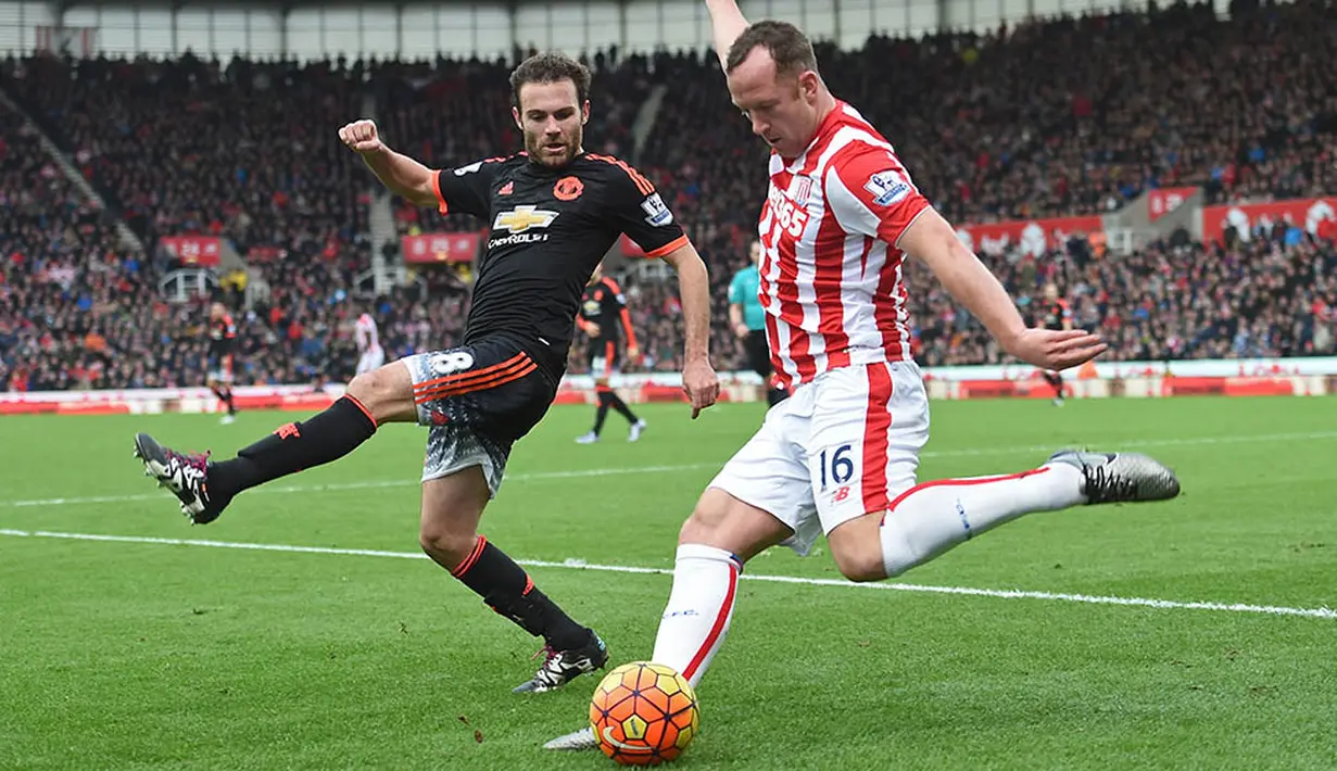 Gelandang Stoke, Charlie Adam, dihadang pemain Manchester United, Juan Mata, saat mencoba memberikan umpan lambung pada laga Liga Inggris. (AFP/Paul Ellis)