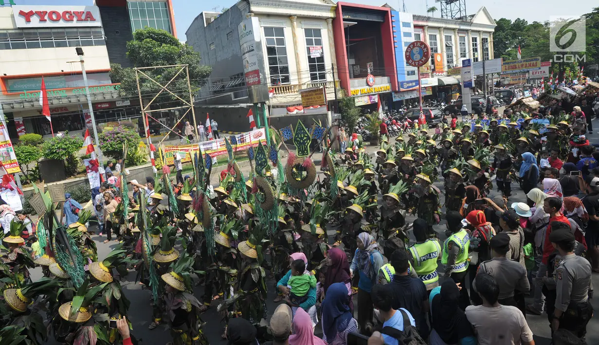 Peserta berkostum dedaunan mengikuti festival budaya Helaran 2018, Bogor, Jawa Barat, Minggu (12/8). Lima ribu peserta berpartisipasi dalam Helaran 2018. (Merdeka.com/Arie Basuki)