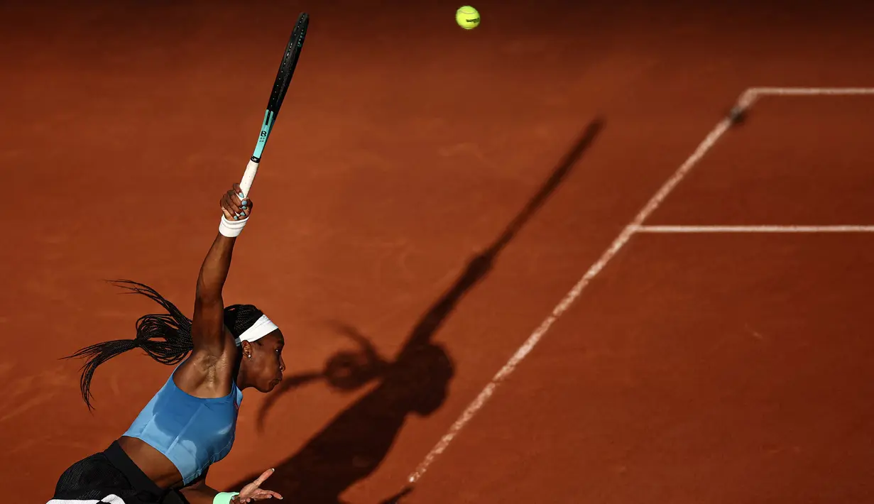 Petenis Amerika Serikat, Coco Gauff melakukan servis ke arah petenis Austria, Julia Grabher pada laga hari kelima Prancis Terbuka 2023 di Roland Garros, Paris, 1 Juni 2023. (AFP/Anne-Christine Poujoulat)