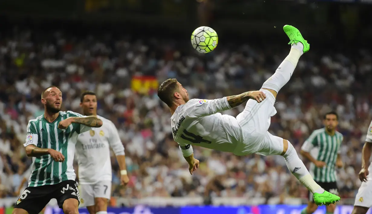 Kapten Real Madrid, Sergio Ramos melakukan tendangan salto saat timnya menang besar 5-0 atas Real Betis Balompie  pada laga La Liga Spanyol di Stadion Santiago Bernabeu, Madrid, (29/8/2015). (AFP Photo/Pierre-Philippe Marcou)