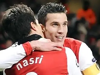 Selebrasi Robin van Persie yang disambut Samir Nasri, usai membuka kemenangan Arsenal 3-1 atas Partizan Belgrade pada partai pamungkasGrup H Liga Champions di Emirates Stadium, 9 Desember 2010. AFP PHOTO/CARL DE SOUZA