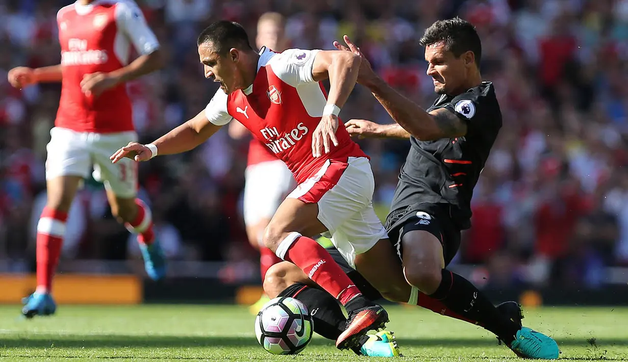 Penyerang Arsenal, Alexis Sanchez, berusaha melewati hadangan bek Liverpool, Dejan Lovren. Pada laga ini sebagai tuan rumah, The Gunners langsung  bermain menyerang sejak awal laga. (AFP/Lee Mills)