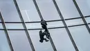 Pendaki kota Prancis, Alain Robert saat berusaha memanjat gedung XYZ di Frankfurt am Main, Sabtu (28/9/2019). Alain yang dikenal sebagai "The French Spiderman" kembali memanjat gedung tinggi di kota Jerman tersebut. (AFP Photo/Daniel Roland)