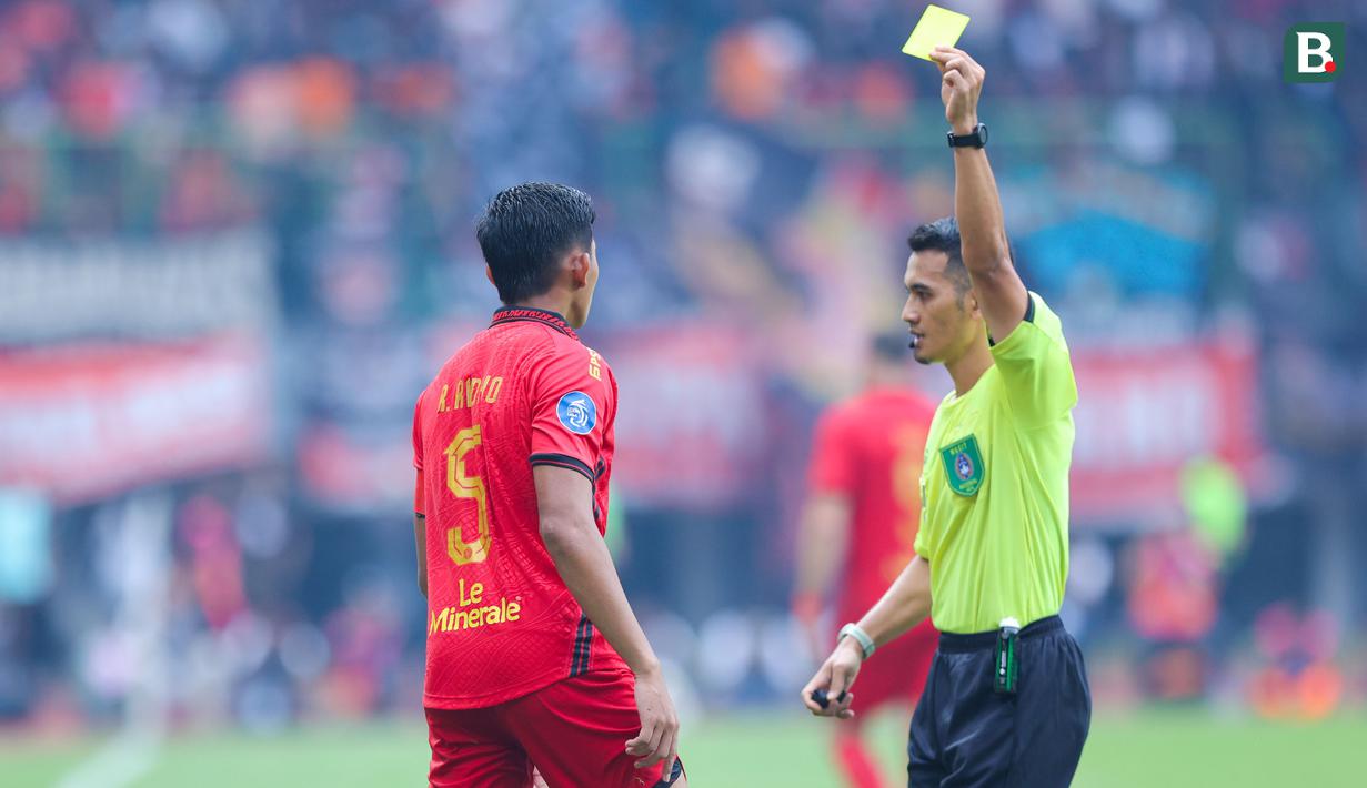 Pemain Persija Jakarta, Rizky Ridho, mendapat kartu kuning setelah melakukan pelanggaran terhadap pemain Persib Bandung, Beckham Putra, dalam lanjutan Liga 1 Indonesia 2024/2025 di Stadion Patriot Candrabhaga, Bekasi, pada Minggu (16/2/2025). (Bola.com/M Iqbal Ichsan)