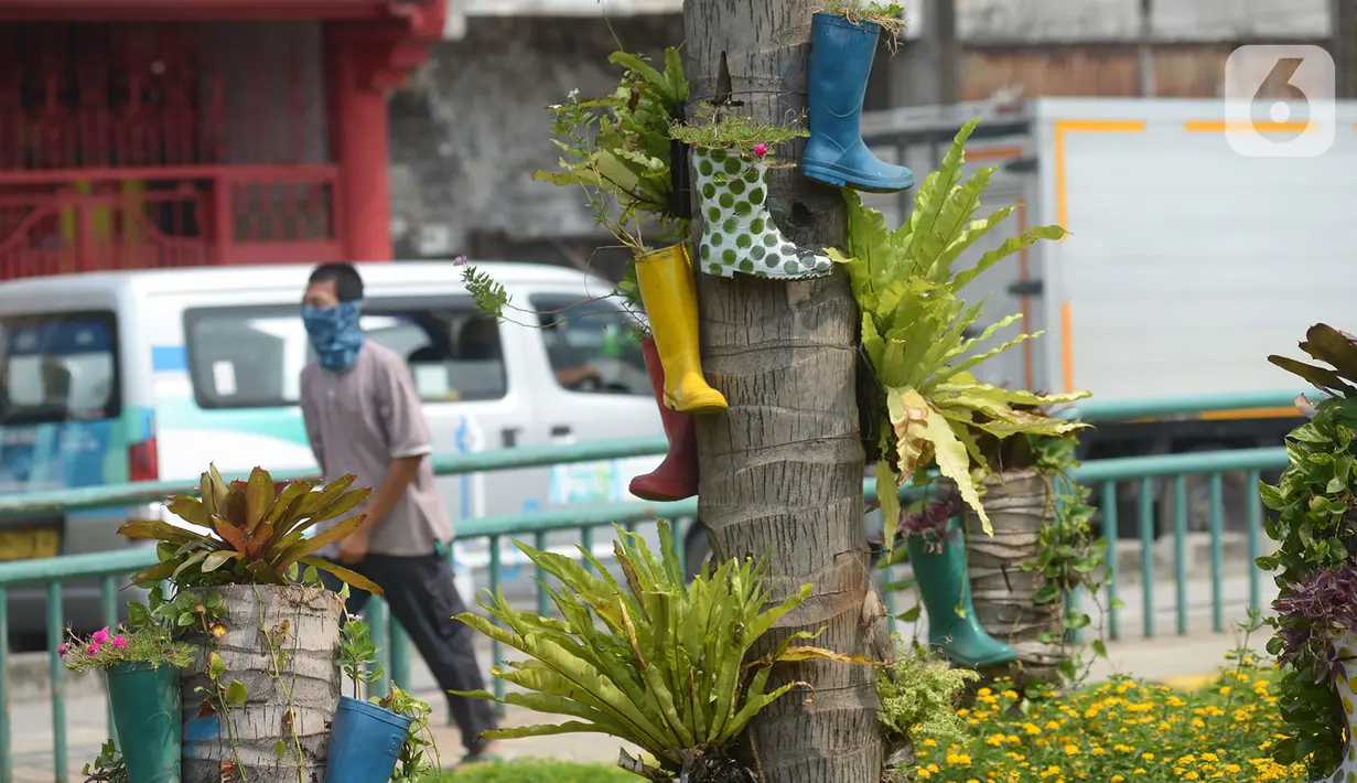 Sepatu bot dijadikan pot hias tanaman di kawasan Kota Tua, Jakarta, Jumat (7/8/2020). Lahan tersebut dipercantik dengan hiasan pot dari sepatu bot yang diwarnai untuk mempercantik lahan kosong di Ibu Kota. (merdeka.com/Imam Buhori)