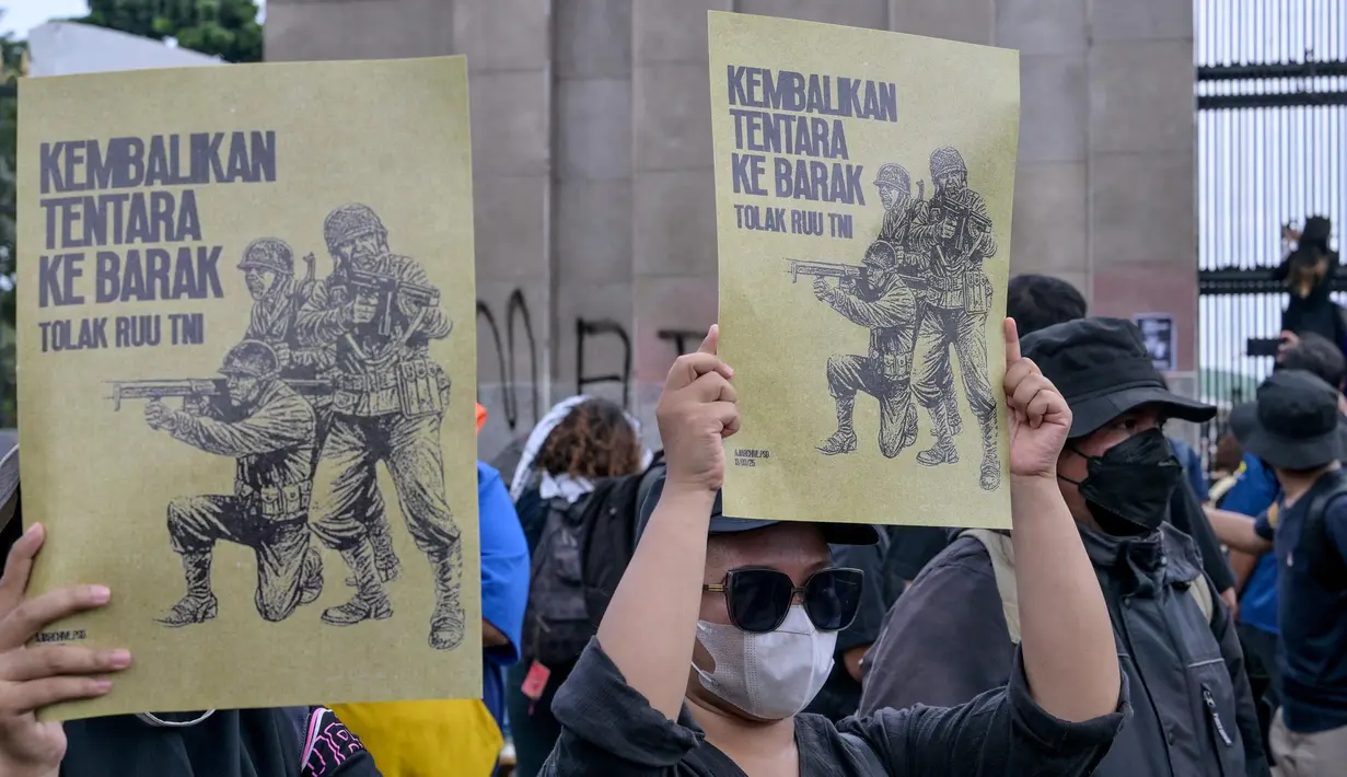 Para mahasiswa menunjukkan plakat bertuliskan “Kembalikan Tentara ke Barak” dalam sebuah protes menentang Revisi Undang-Undang Tentara Nasional Indonesia (RUU TNI) di depan gedung DPR di Jakarta pada tanggal 20 Maret 2025. (BAY ISMOYO/AFP)