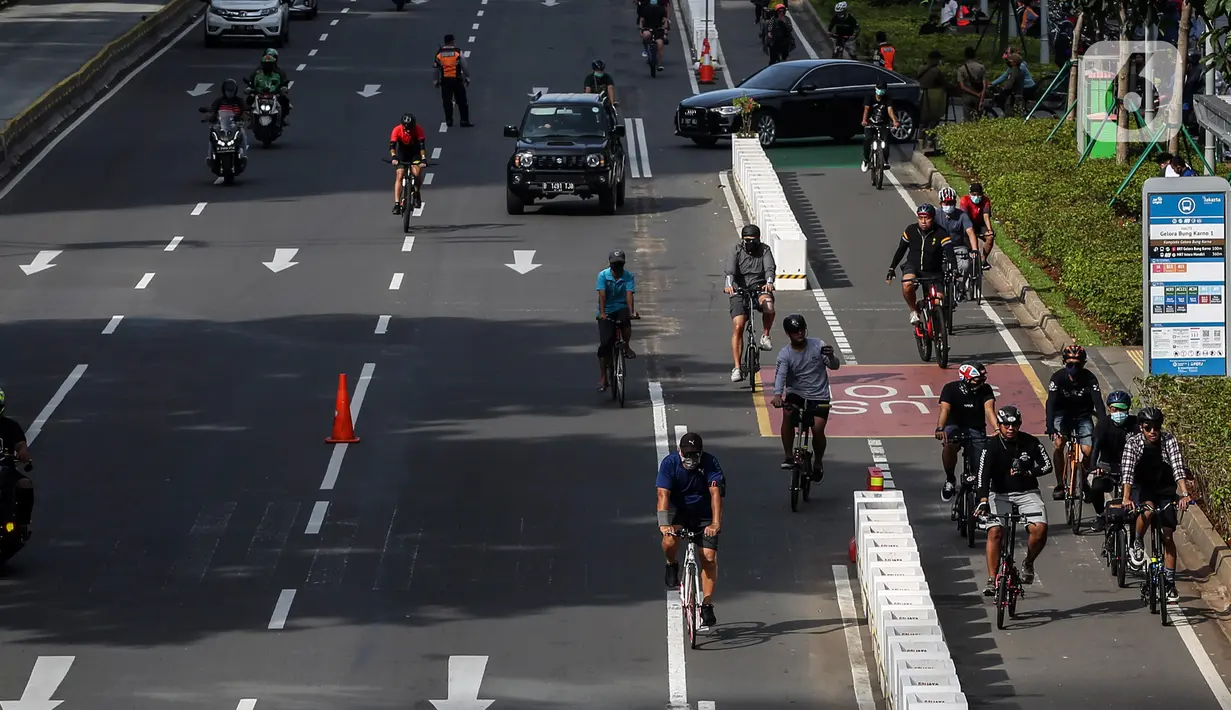 Warga bersepeda saat uji coba pembatas jalur sepeda permanen di kawasan Sudirman, Jakarta, Minggu (28/2/2021). Dalam uji coba tersebut terlihat masih banyak pesepeda yang melintas di luar jalur khusus yang telah disediakan. (Liputan6.com/Johan Tallo)