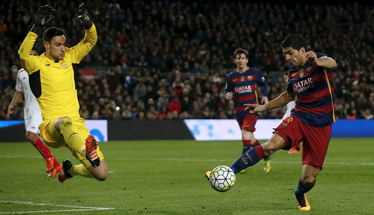 4. Striker Barcelona, Luis Suarez, berupa mengecoh kiper Sevilla, Sergio Rico, pada laga La Liga Spanyol di Stadion Camp Nou, Minggu (28/2/2016). Bercelona berhasil menang 2-1 atas Sevilla. (Reuters/Albert Gea)