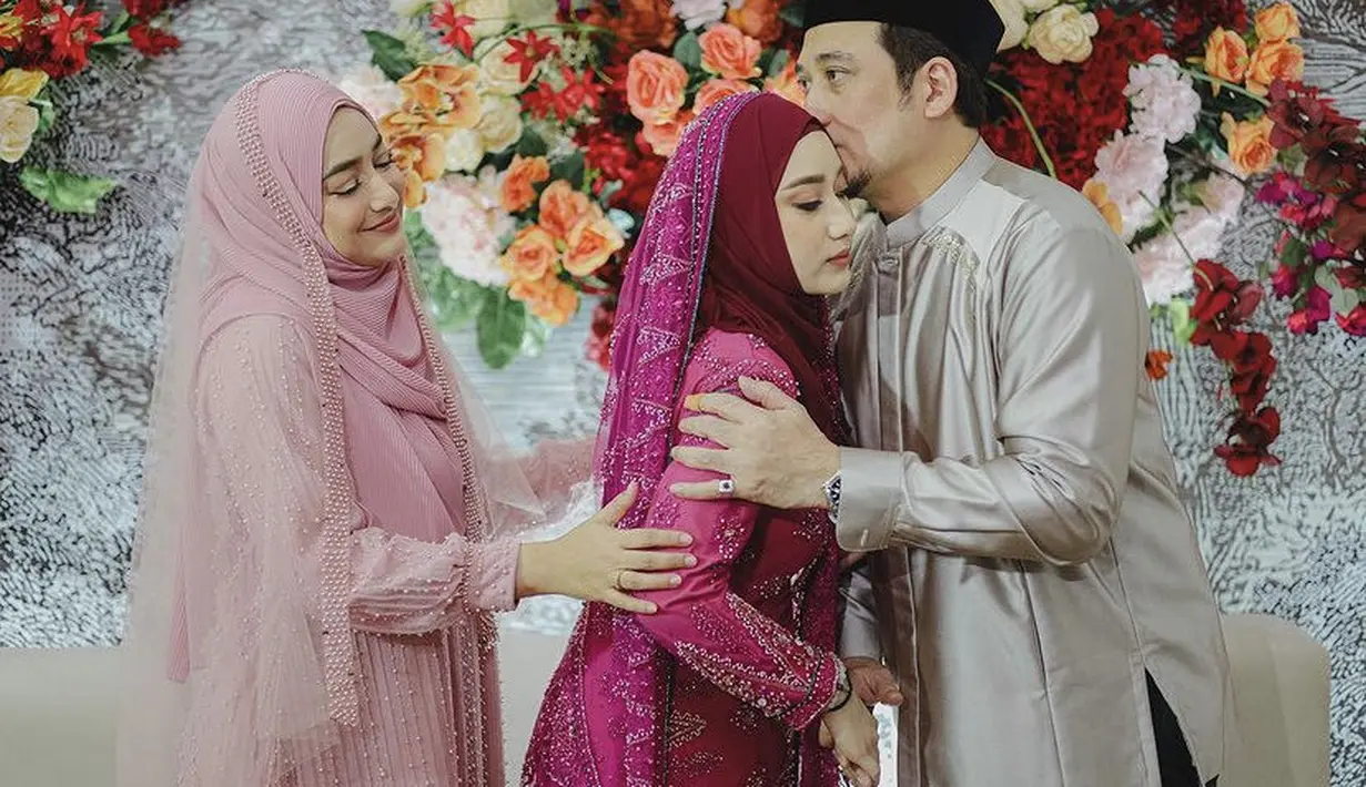 Saat pengajian, Cindy tampil dengan pakaian serba pink dengan dress plisket bertabur aksen mutiara, lengkap dengan hijab panjang dan veil warna serasi. @nandito_photography.