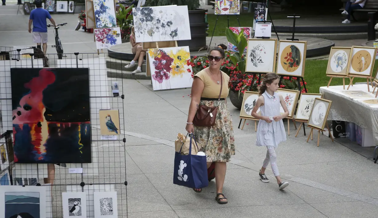 Sejumlah orang mengamati karya seni yang dipajang di area terbuka dalam pameran Art Downtown, Vancouver, British Columbia, Kanada, 4 September 2020. Art Downtown merupakan proyek yang memungkinkan seniman dan publik saling terhubung dan menginspirasi serta berbagi kreativitas. (Xinhua/Liang Sen)