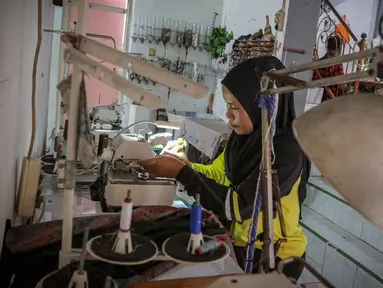 Pekerja menjahit pakaian yang diproduksi di salah satu industri konveksi rumahan di Kawasan Cipadu, Kota Tangerang, Banten, Selasa (9/1/2024). (Liputan6.com/Angga Yuniar)