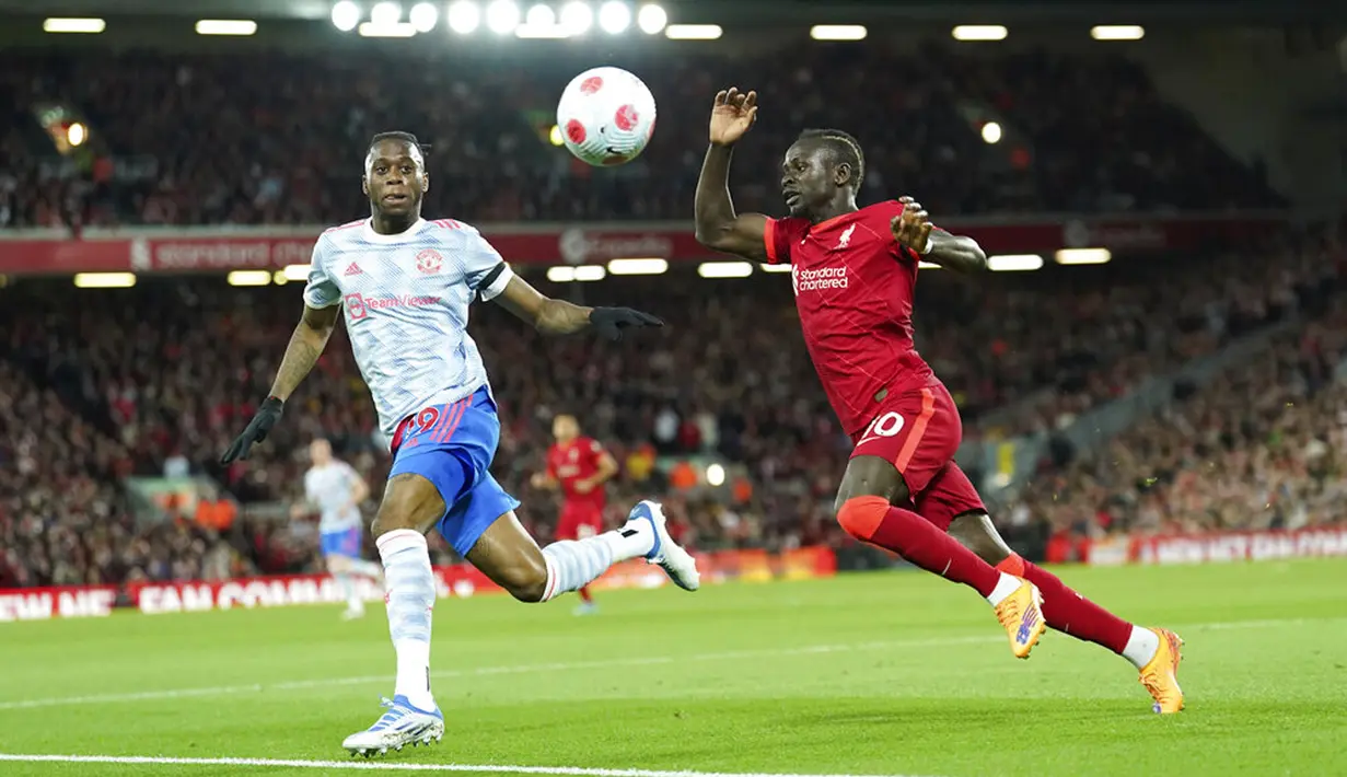 Pemain Liverpool Sadio Mane (kanan) berebut bola dengan pemain Manchester United Aaron Wan-Bissaka pada pertandingan sepak bola Liga Inggris di Stadion Anfield, Liverpool, Inggris, 19 April 2022. Liverpool menang 4-0. (AP Photo/Jon Super)