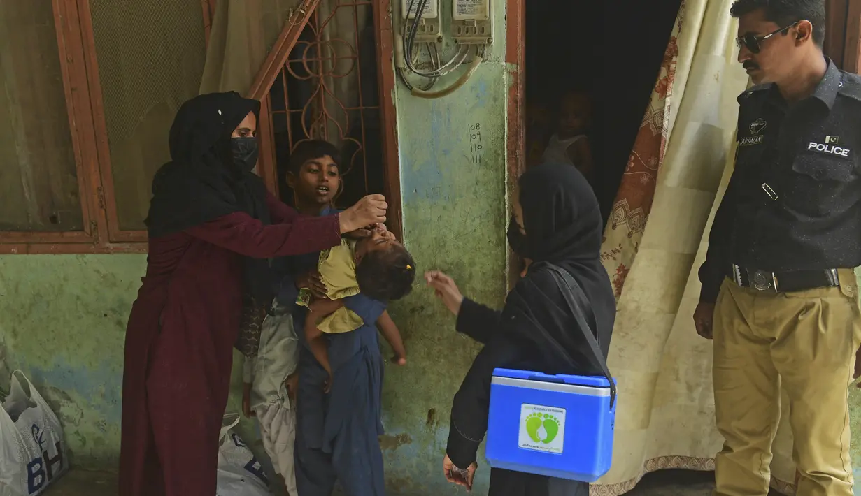 <p>Petugas kesehatan memberikan vaksin polio kepada seorang anak selama kampanye vaksinasi polio dari pintu ke pintu di daerah kumuh di Karachi, Paksistan, Senin (23/5/2022). Pakistan meluncurkan upaya anti-polio baru pada hari Senin, lebih dari seminggu setelah pejabat mendeteksi kasus ketiga tahun ini di wilayah barat laut negara itu yang berbatasan dengan Afghanistan. (Asif HASSAN / AFP)</p>