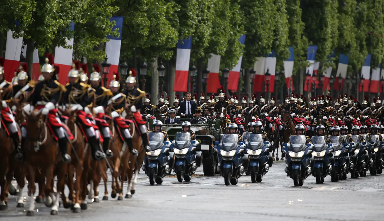 Suasana arak-arakan Presiden terpilih Prancis Emmanuel Macron saat berparade di jalan Champs Elysees usai upacara peresmian sebagai Presiden Prancis, Paris, Minggu (14/5). (AFP PHOTO / CHARLY TRIBALLEAU)