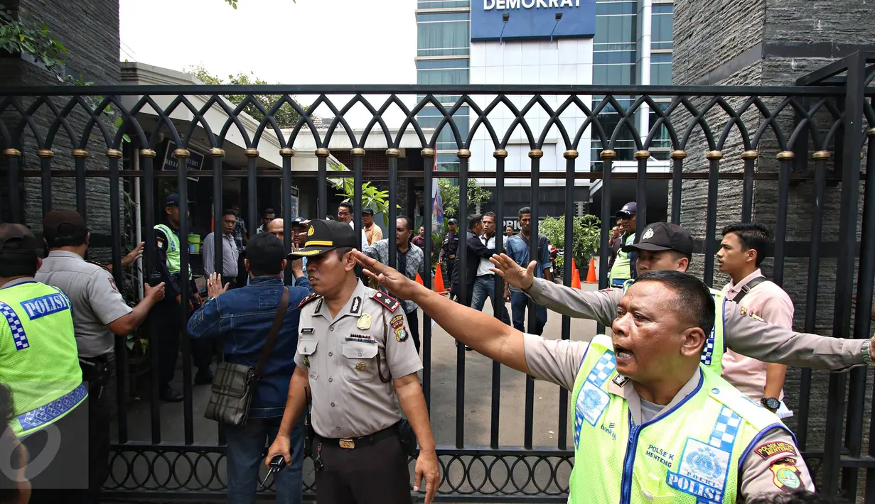 Petugas kepolisian saat membubarkan massa dari Solidaritas Pergerakan Mahasiswa Indonesia yang mencoba melakukan demo di depan Kantor DPP NasDem, Jakarta, Senin (18/1). Kejadian tersebut juga diwarnai aksi lempar batu.(Liputan6.com/Immanuel Antonius)