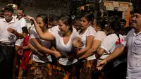 Peserta perempuan mempersiapkan kelompok mereka selama tradisi Omed-omedan (cium-ciuman) di Denpasar, Bali, Jumat (4/3/2022). "Omed-omedan" merupakan ritual tradisi khas muda-mudi yang dilaksanakan sehari setelah Hari Raya Nyepi. (AP Photo/Firdia Lisnawati)