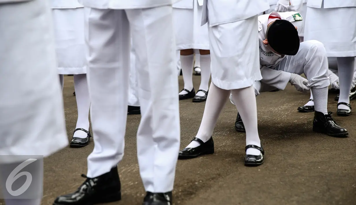 Anggota pria paskibraka 2016 merapikan kaos kaki saat bersiap melaksanakan gladi bersih upacara HUT ke-71 Kemerdekaan RI di Istana Merdeka, Jakarta, Senin (15/8). (Liputan6.com/Faizal Fanani)