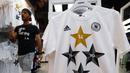 Salah satu petugas toko di Frankfurt, (14/7/2014), melintas diantara kaos-kaos berlogo federasi sepak bola Jerman dengan empat bintang. (REUTERS/Ralph Orlowski)