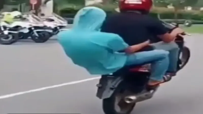 Aksi remaja di Pekanbaru mengangkat ban depan sepeda motor di depan polisi.