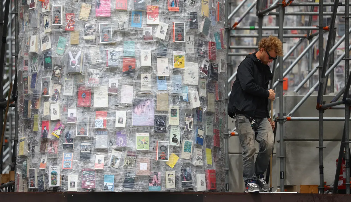 Pekerja membersihkan lantai di sekitar proyek instalasi seni "Temple of books" atau Kuil Buku yang sedang dalam proses penyelesaian jelang pembukaan pameran seni terbesar Jerman "Documenta 14" di Kassel, Jerman (7/6). (Reuters/Kai Pfaffenbach)
