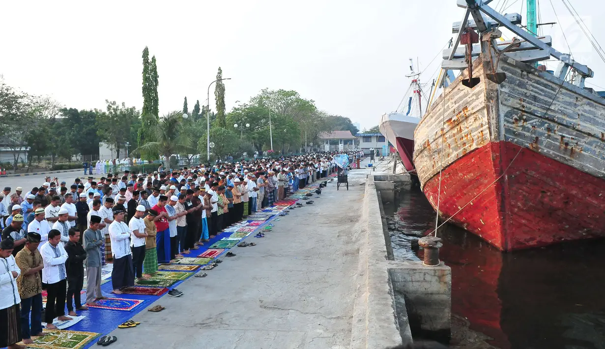 Umat muslim menjalankan Salat Idul Adha 1438 H di kawasan Pelabuhan Sunda Kelapa, Jakarta, Jumat (1/9). Setelah menjalankan salat, umat muslim melakukan penyembelihan hewan kurban. (Liputan6.com/Helmi Afandi)