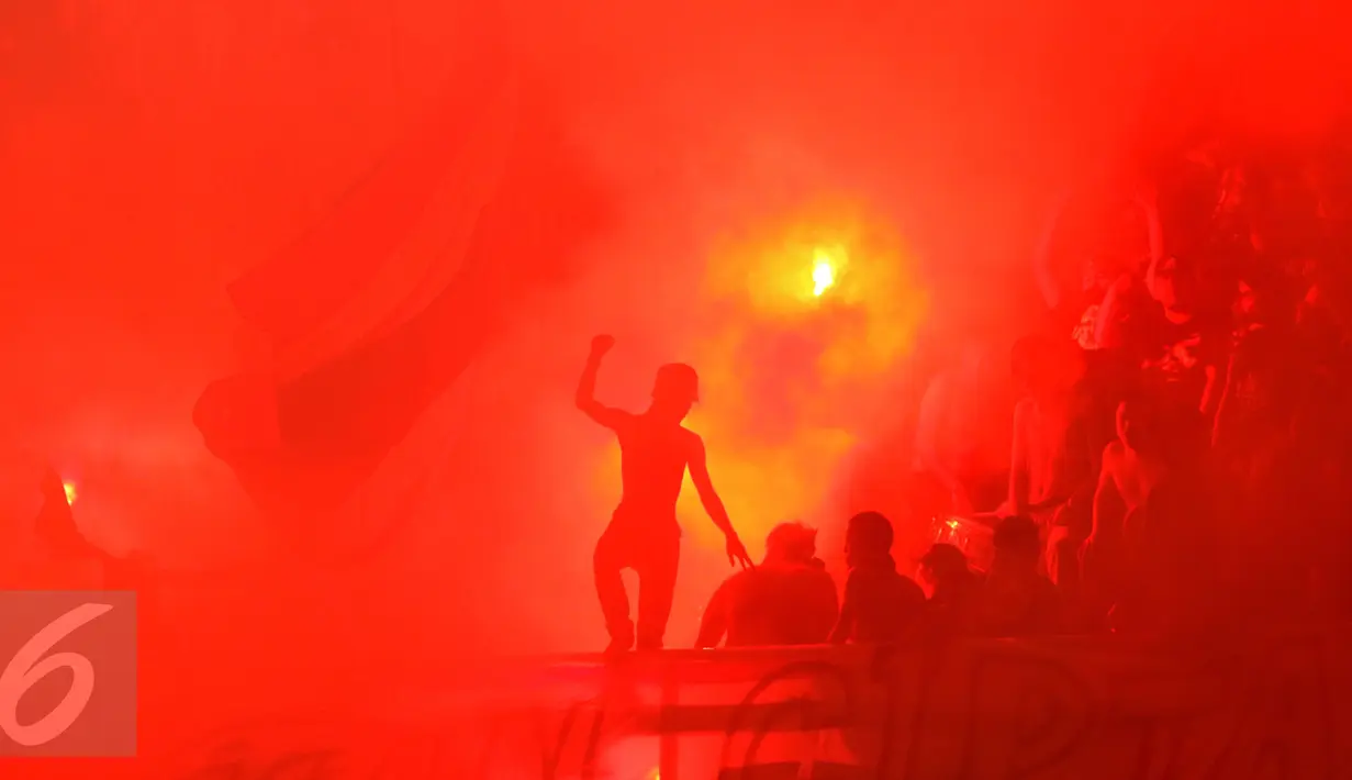 Suporter Timnas Thailand berdiri di depan suar saat menyambut kemenangan timnya atas Indonesia di National Stadium Rajamangala, Bangkok, Sabtu (17/12). Thailand berhasil meraih piala AFF untuk yang kelima kali. (Liputan6.com/Helmi Fithriansyah)