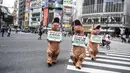 Aktivis kelompok hak hewan PETA mendesak orang untuk menjadi vegan selama protes di Tokyo, Jepang, Rabu (6/10/2021). Dalam aksinya, para aktivis mengenakan kostum dinosaurus. (CHARLY TRIBALLEAU/AFP)