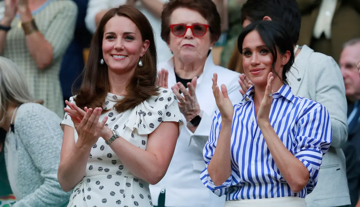 Duchess of Cambridge Kate Middleton dan Duchess of Sussex Meghan Markle bertepuk tangan saat menyaksikan pertandingan Serena Williams dan Angelique Kerber di kejuaraan  tenis Wimbledon di London, Inggris, (14/7). (AP Photo/Andrew Couldridge)