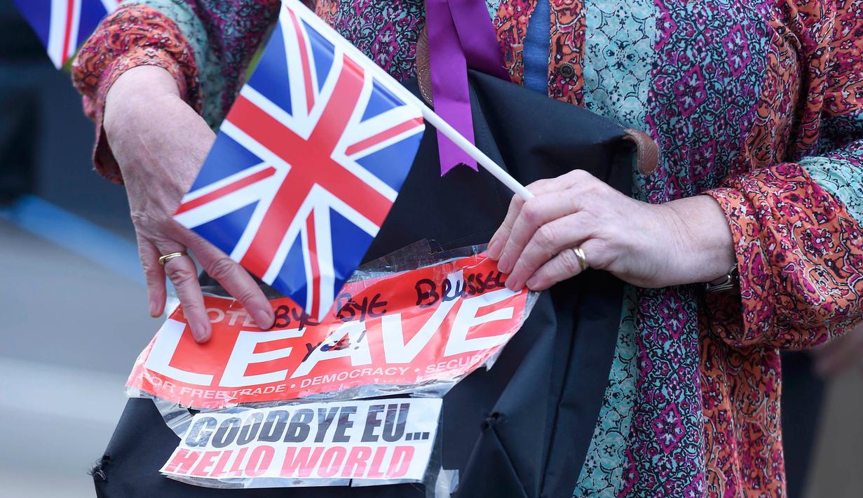 Pendukung Brexit memegang poster dan bendera Inggris di Westminster, London, Kamis (23/6). Perhitungan suara hasil Referendum Brexit menunjukkan mayoritas rakyat Inggris memilih “Brexit” alias keluar dari Uni Eropa. (REUTERS/Toby Melville)