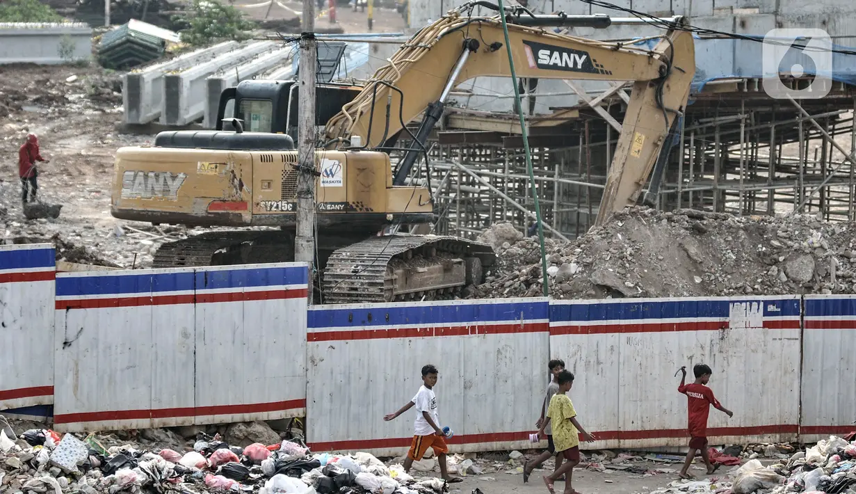 Anak-anak melintas dekat proyek pembangunan Tol Becakayu seksi 1A di kawasan Pasar Gembrong, Jakarta, Selasa (14/7/2020). Proyek pembangunan Tol Becakayu seksi 1A rute Kampung Melayu-Cipinang Muara sepanjang 3,5 kilometer tersebut molor dari target. (merdeka.com/Iqbal S. Nugroho)