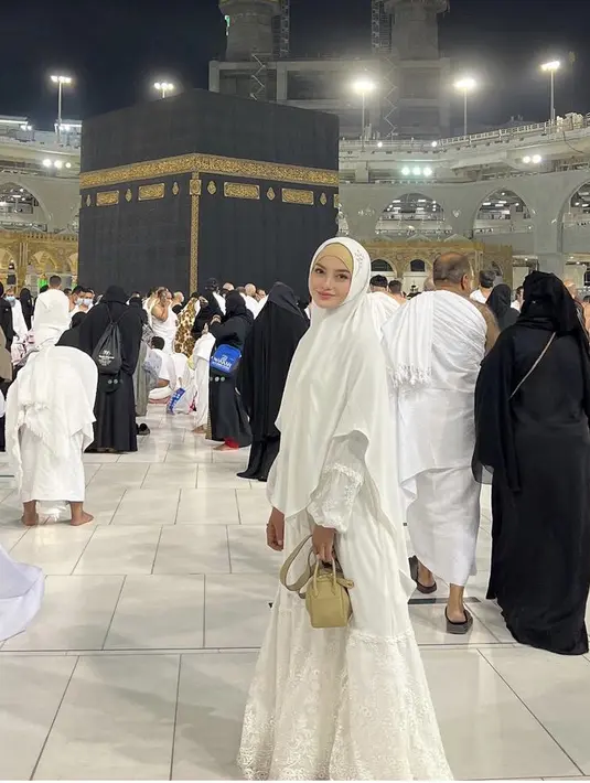 Berpose di depan Kabaah, Ririn mengenakan tampilan serba putih. Dari dress ruffle dengan detail bordir di bagian baaah dan lengan. Ia pun mengenakan bergo syari warna putih.@ririnekawati