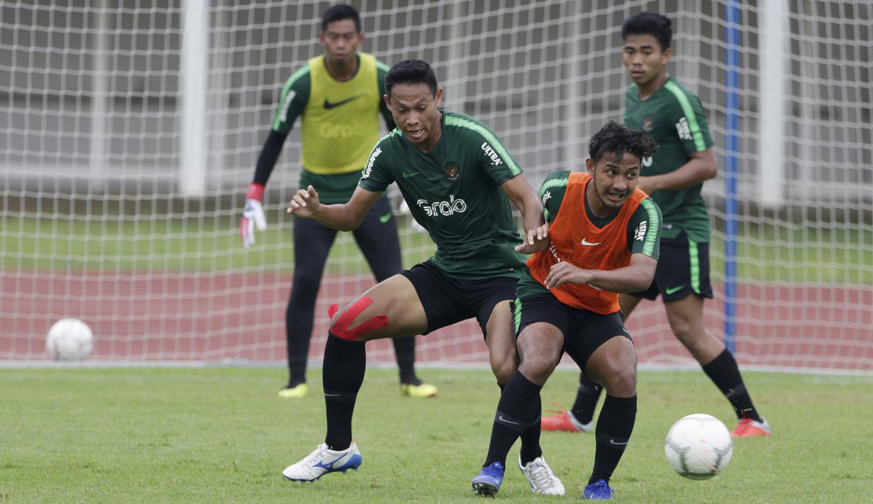 Pemain Timnas Indonesia U-22, Andy Setyo, berebut bola dengan Gian Zola saat latihan di Stadion Madya Senayan, Jakarta, Selasa (22/1). Latihan ini merupakan persiapan jelang Piala AFF U-22. (Bola.com/Yoppy Renato)