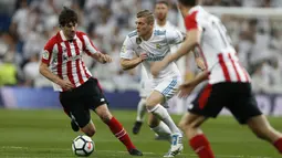 Pemain Real Madrid, Toni Kroos (tengah) mencoba menerobos pertahanan Athletic Bilbao pada lanjutan La Liga Santander di Santiago Bernabeu stadium, Madrid, (18/4/2018). Real Madrid bermain imbang 1-1 dengan Bilbao. (AP/Francisco Seco)