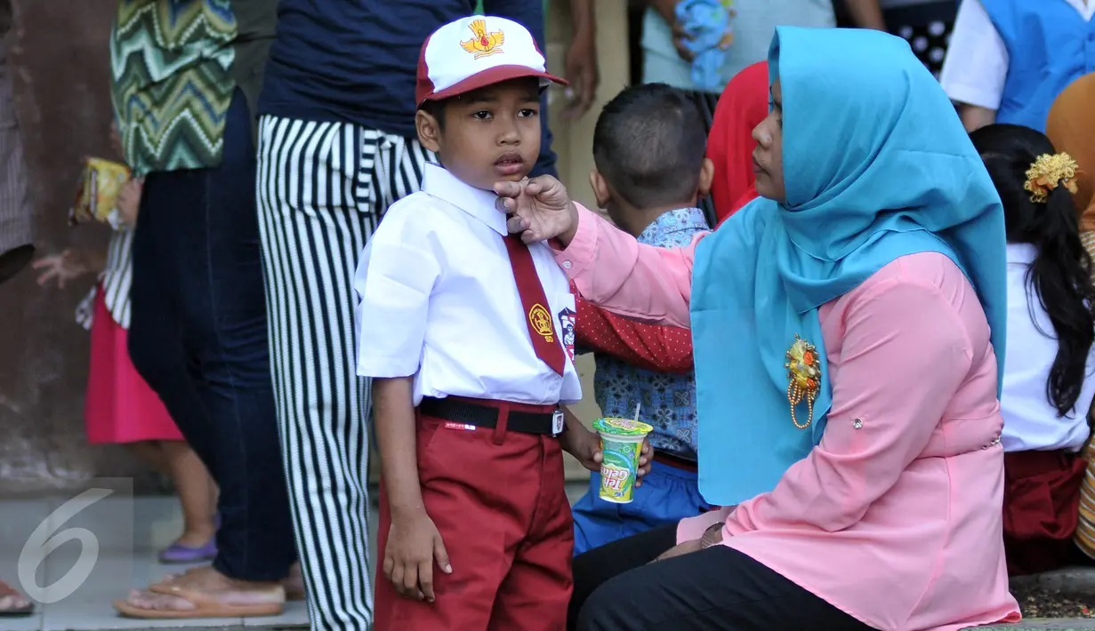 Salah satu orangtua menemani anaknya sebelum masuk kelas di SDN Manggarai 17 Pagi, Jakarta, Senin (18/7). Para orangtua terlihat ramai datang ke sekolah mengantar anaknya pada hari pertama masuk sekolah tahun ajaran 2016/2017. (Liputan6.com/Johan Tallo)