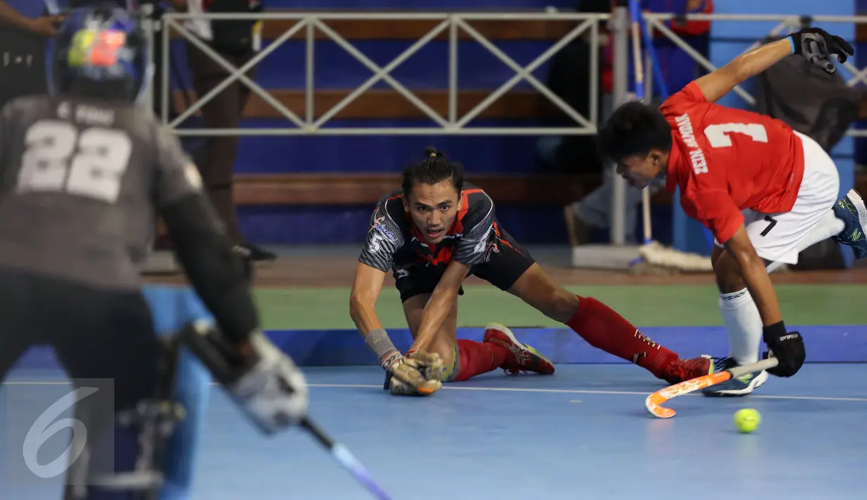 Pemain hoki DKI Jakarta, Daarul Quthni (tengah) berebut bola dengan pemain Jawa Barat saat laga final hoki putra PON XIX Jabar di Gymnasium UPI, Bandung, Senin (19/9). Jawa Barat menundukkan DKI Jakarta dengan skor 3-1. (Liputan6.com/Helmi Fithriansyah)
