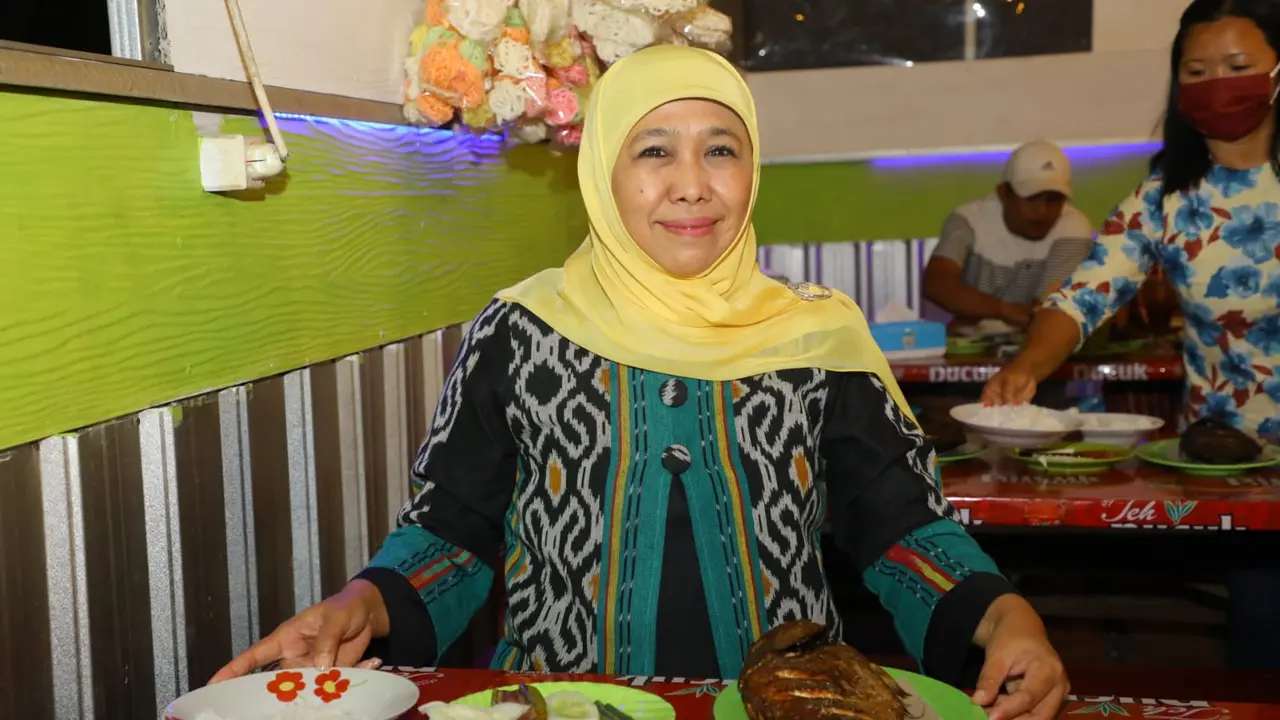Gubernur Jawa Timur Khofifah Indar Parawansa saat mencicipi ikan asap segar. (Liputan6.com/ ist)