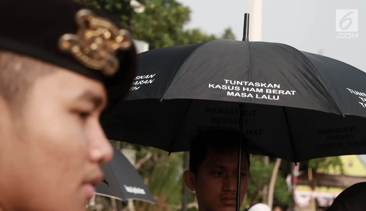 Polisi mengawal massa Jaringan Solidaritas Korban untuk Keadilan (JSKK) saat menggelar Aksi Kamisan di depan Istana Negara, Jakarta, Kamis (2/8). (Merdeka.com/Iqbal Nugroho)