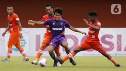 Pemain Persiraja Banda Aceh berusaha menghentikan pergerakan pemain Persita Tangerang Rifky Dwi Septiawan dalam pertandingan babak penyisihan Piala Menpora 2021 di Stadion Maguwoharjo, Sleman, Rabu (24/3/2021). Persiraja menang 3-1. (Bola.com/Arief Bagus)
