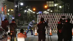 Petugas membuka gerbang ke kota Futaba, prefektur Fukushima, Jepang utara, Rabu (4/3/2020). Pembukaan masuk sebagian kota ini merupakan upaya pemerintah Jepang untuk memulihkan kepercayaan masyarakat, dan kesiapan mereka dalam menggelar Olimpiade Tokyo pada Agustus mendatang. (Kyodo News via AP)