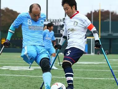 Pemain FC Kyushu Shintaro Kaminaka (kiri) berebut bola dengan pemain FC Alvorada Yoshihiko Endo saat pertandingan final di Jepang. FC Kyushu Bairaor merupakan tim profesional pertama yang pemainnya memiliki cacat fisik. (Aflo/Rex Shutterstock/Dailymail)