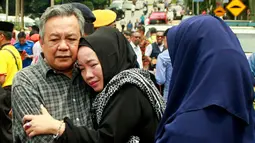 Suasana haru yang menyelimuti kedua orang tua dari korban kebakaran sekolah agama Darul Quran Ittifaqiyah di Kuala Lumpur, Malaysia (14/9). Kebakaran tersebut terjadi pada Kamis dini hari waktu setempat. (AFP Photo/Sadiq Asyraf)