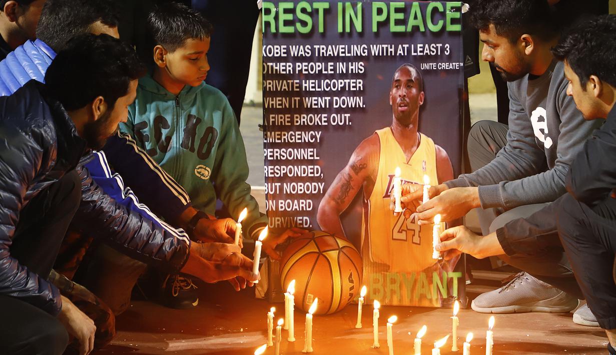 Sejumlah warga menyalakan lilin untuk mengenang wafatnya Kobe Bryant di Gurgaon, India, Senin(26/1). Akibat kecelakaan helikopter, legenda NBA itu wafat bersama sang putri. (AFP/Manoj Kumar)