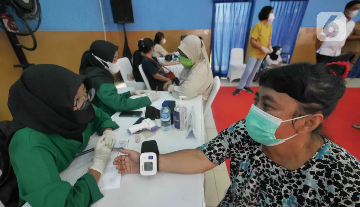 Petugas mengecek kesehatan warga saat gelaran Vaksin Covid-19 Serentak di GOR Radio Dalam, Jakarta Selatan, Selasa (8/3/2022). Vaksinasi serentak digelar di seluruh Indonesia yang diselenggarakan Kepolisian RI dengan target penyaluran vaksin sebanyak 1.114.750 dosis. (Liputan6.com/Herman Zakharia)