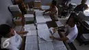 Pekerja menyusun lembaran buku iqro di Kota Gede, Yogyakarta, (13/6). Selama bulan ramadan produksi tetap berjalan untuk memenuhi permintaan masyarakat yang ingin belajar membaca alquran dengan cepat. (Liputan6.com/Boy Harjanto)