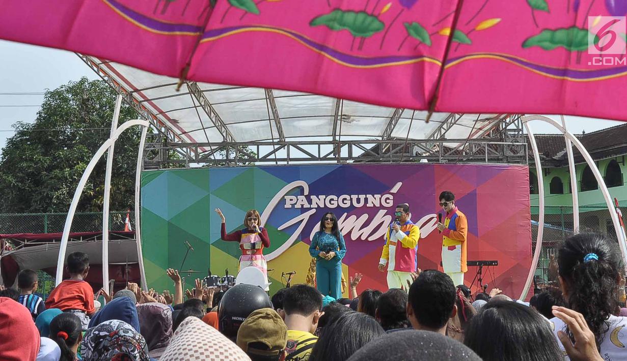 Penyanyi dangdut Rita Sugiarto (dua kiri) saat tampil dalam Panggung Gembira di Semarang, Jawa Tengah, Sabtu (15/12). Sejumlah artis dangdut ternama menghibur masyarakat Semarang. (Liputan6.com/Gholib)