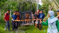 Personel BBKSDA Riau dan masyarakat Kota Dumai memasang perangkap dari kerangkeng untuk menangkap beruang masuk pemukiman. (Liputan6.com/M Syukur)