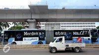 Sebuah mobil melintas di sebelah bus Transjakarta di Terminal Blok M, Jakarta Selatan, Kamis (12/1). PT Transjakarta tambah 2.000 unit bus, sehingga pada akhir tahun 2017 jumlah bus yang dimiliki bisa mencapai 3.300 unit. (Liputan6.com/Gempur M. Surya)