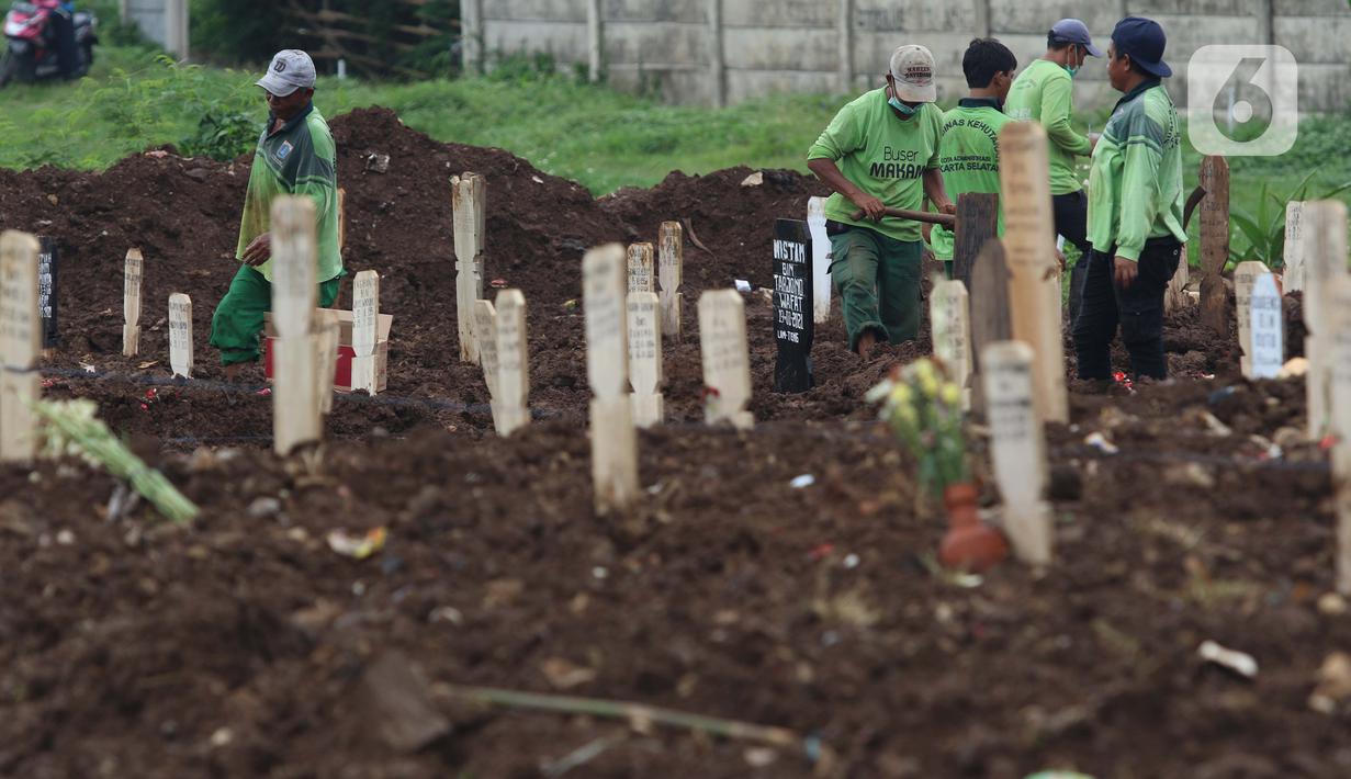 Petugas merapikan area makam jenazah dengan protokol COVID-19 di TPU Srengseng Sawah, Jakarta, Kamis (21/1/2021). Sebagian lahan TPU Srengseng Sawah dijadikan pemakaman jenazah Covid-19 sejak Selasa (12/1) lalu, dengan kapasitas 564 petak makam kini nyaris penuh. (Liputan6.com/Helmi Fithriansyah)