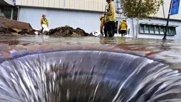 Beberapa petugas pemadam kebakaran berusaha mengatasi kerusakan pipa utama saluran air bawah tanah di sekitar Sunset Boulevard di bagian Westwood Los Angeles, (29/7/2014). (REUTERS/Jonathan Alcorn)