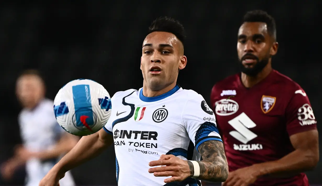 Penyerang Inter Milan Lautaro Martinez (kiri) dan bek Torino Pantai Gading Koffi Djidji berebut bola selama pertandingan lanjutan Liga Serie A Italia di stadion Olimpiade di Turin, Senin (14/3/2022). Torino bermain imbang atas Inter Milan 1-1. (AFP/Marco Bertorello)
